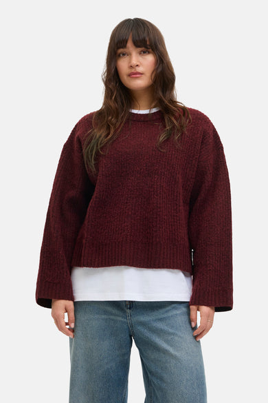 Veste Bordeaux avec col rond de JJXX, portée sur un T-shirt blanc et des jeans bleus.