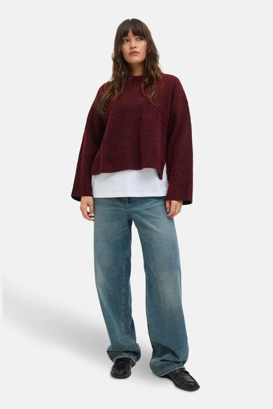Veste Bordeaux avec col rond de JJXX, portée sur une chemise blanche et des jeans larges et des loafers noirs.