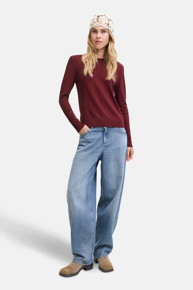 T-shirt rouge avec col rond de JJXX, porté avec des jeans larges et un bonnet tricoté.