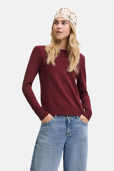 T-shirt rouge avec col rond de JJXX, porté avec un chapeau tricoté et des jeans bleus.