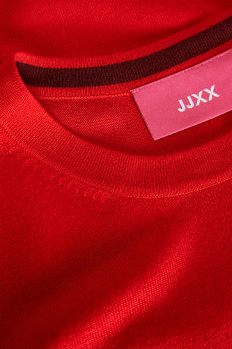 T-shirt rouge avec col rond de JJXX, avec une ligne de col rayée et un étiquette de marque rose.