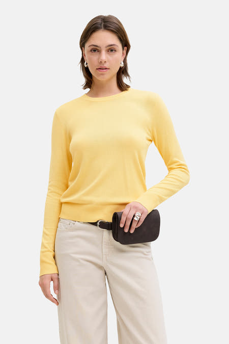 Pull jaune à col rond de JJXX, combiné avec une banane marron et un pantalon beige.