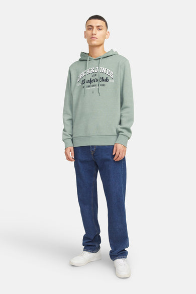 Pull à capuche vert de ORIGINALS BY JACK & JONES, avec un jean bleu foncé et des baskets blanches.