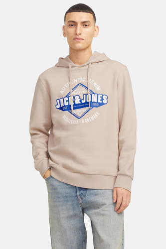 Pull beige à capuche ORIGINALS BY JACK & JONES, avec un imprimé logo sur la poitrine, porté avec un jean.