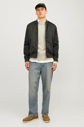 Groene korte jas van CORE BY JACK & JONES, gedragen met een trui en een wit overhemd, gecombineerd met blauwe jeans en bruine veterschoenen.
