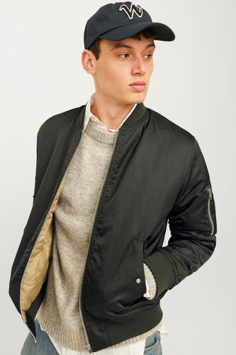 Veste verte de CORE BY JACK & JONES, avec fermeture à glissière, poches et un homme avec un chapeau.