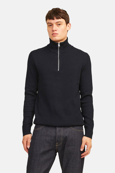 Sweat-shirt noir à col rond de CORE BY JACK & JONES, avec une fermeture éclair argentée et une texture rayée, associé à des jeans foncés.