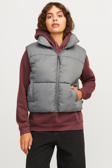 Gilet gris de JJXX, stylé avec une hoodie bordeaux et des jeans noirs.