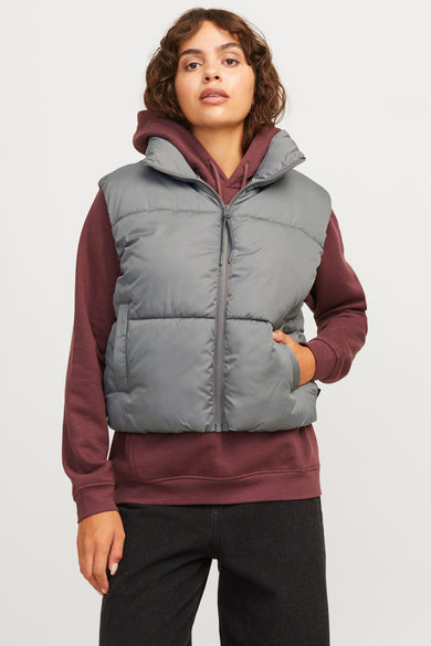Gilet gris de JJXX, stylé avec une hoodie bordeaux et des jeans noirs.