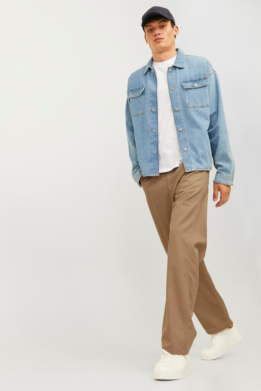 Beige broek van JACK & JONES JEANS INTELLIGENCE, gecombineerd met een spijkerblouse, wit T-shirt en witte sneakers.