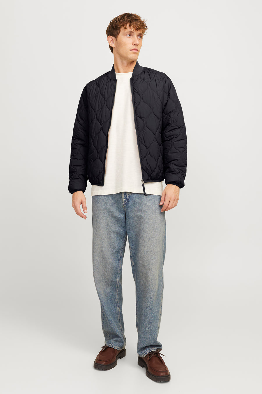 Manteau court noir de PREMIUM BLUE par JACK & JONES, avec un motif à carreaux et porté avec un t-shirt blanc et des jeans bleus.