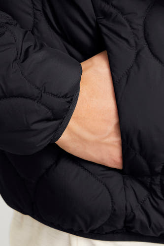 Manteau court noir de PREMIUM BLUE par JACK & JONES, avec une main dans la poche.