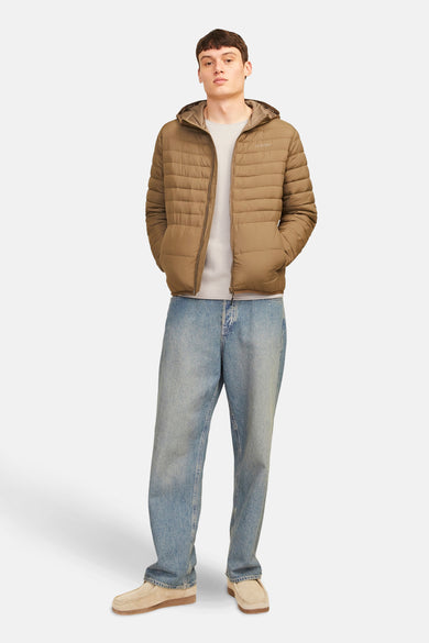 Gilet beige avec col rond de PREMIUM BLUE par JACK & JONES, porté avec un manteau brun fourré et des jeans larges.