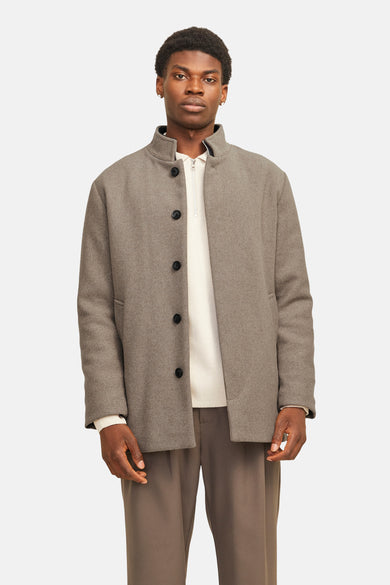 Manteau long beige de PREMIUM par JACK & JONES, avec fermeture à boutons et une chemise blanche en dessous.