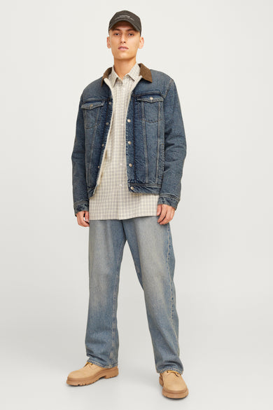 Donkerblauwe denim jeansjas van JACK & JONES JEANS INTELLIGENCE, met bruine kraag, gedragen over een geruit overhemd en wijde jeans.