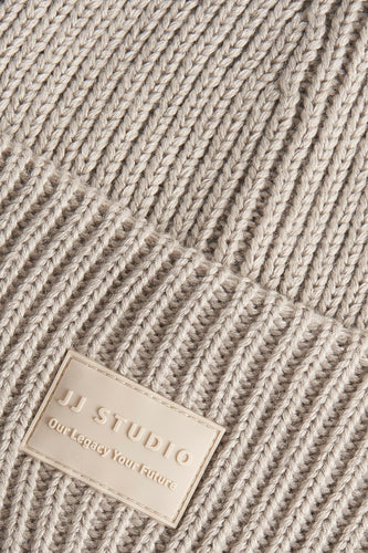 Beige gebreide muts met logo.
