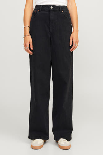 Jean en denim noir de JJXX, avec des jambes larges et des bijoux argentés autour des poignets.