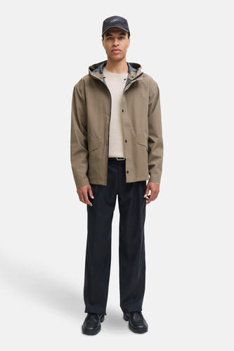 Pull beige à col rond de PREMIUM by JACK & JONES, porté avec un manteau kaki et une pantalon noir.