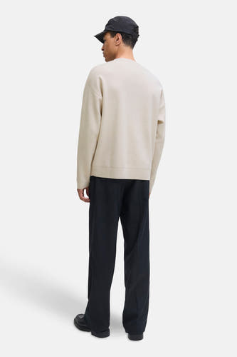 Pull beige à col rond de PREMIUM by JACK & JONES, vu de l'arrière, avec un pantalon noir et une casquette.