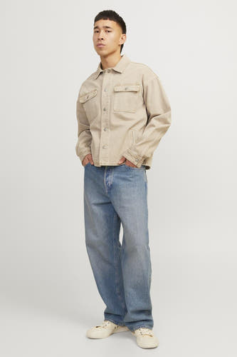 Jean ALEX mid blue denim coupe large de JACK & JONES JEANS INTELLIGENCE, combiné avec une veste beige et des chaussures blanches.