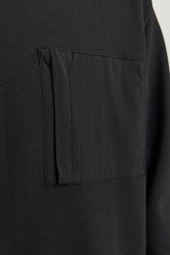 Gilet noir de CORE BY JACK & JONES, avec une poche rectangulaire sur la poitrine.