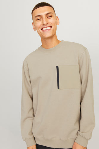 Lachende man in beige trui met zak.