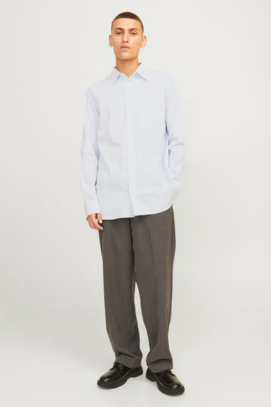 Blauw overhemd met lange mouwen van PREMIUM by JACK & JONES, met een fijne streep en gedragen met een grijze pantalon.
