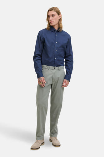 Chemise bleue à manches longues de PREMIUM by JACK & JONES, portée avec un pantalon gris et des chaussures en cuir de suède.