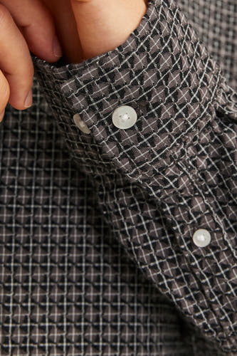 Chemise brune à manches longues d'ORIGINALS BY JACK & JONES, gros plan sur la manche avec un motif à carreaux et des boutons.