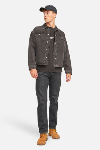 Zwarte denim jeans van JACK & JONES JEANS INTELLIGENCE, gedragen met een denim jas, T-shirt en bruine laarzen.