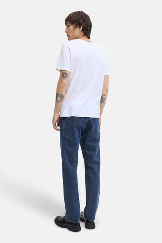 Jean bleu marine droit de JACK & JONES JEANS INTELLIGENCE, avec des poches arrière visibles et porté avec un T-shirt blanc et des chaussures noires.