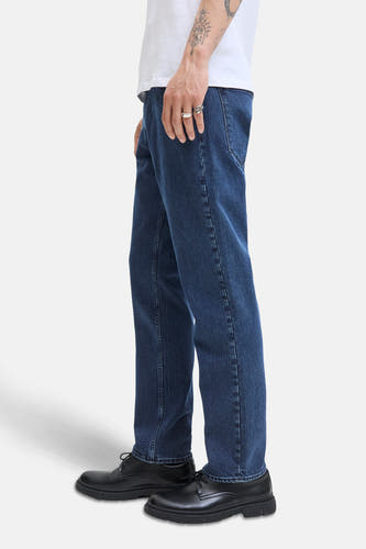 Jean bleu marine droit de JACK & JONES JEANS INTELLIGENCE, associé à des chaussures noires et un t-shirt blanc, vue latérale.