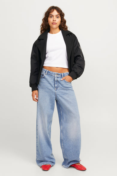 Zwarte korte jas van JJXX, gedragen met een wit shirt en wijde blauwe jeans.