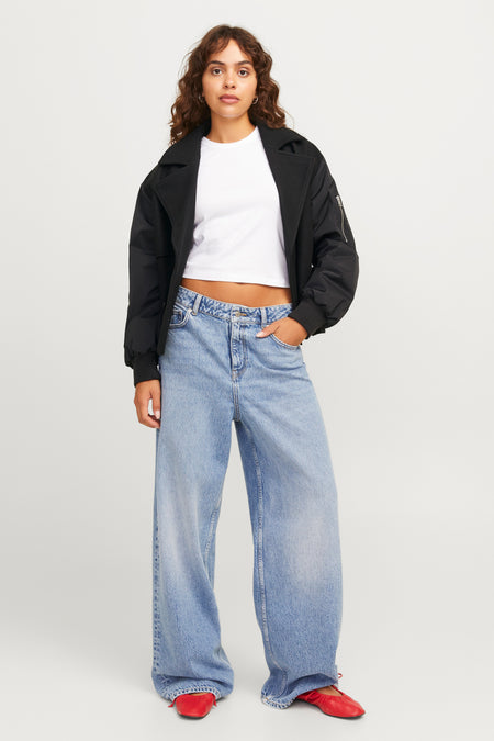 Zwarte korte jas van JJXX, gedragen met een wit shirt en wijde blauwe jeans.