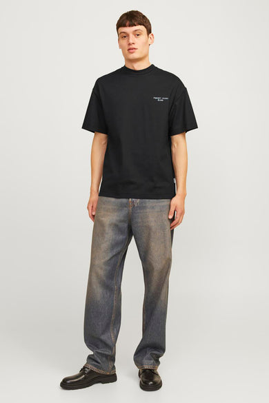 T-shirt noir à manches courtes d'ORIGINALS BY JACK & JONES, porté avec des jeans larges et des chaussures noires.