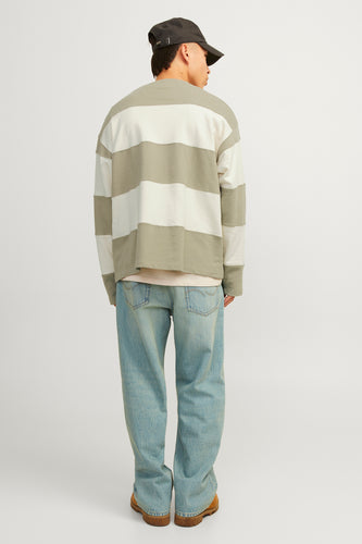 Man van achteren, gestreept shirt, blauwe jeans, bruine schoenen, grijze pet.
