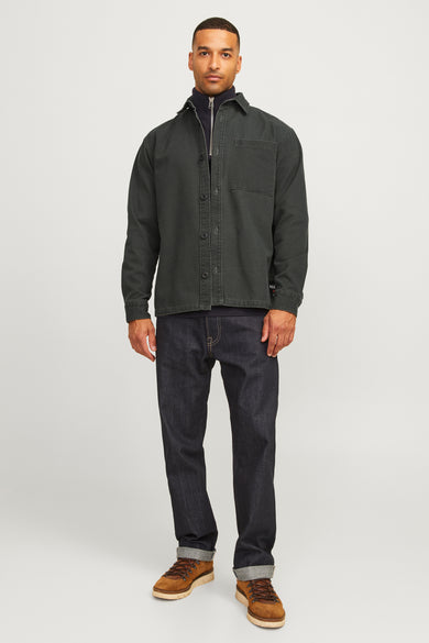 Groen hemd met lange mouwen van Royal Denim Division, met een borstzak en gedragen over een trui en donkere jeans.
