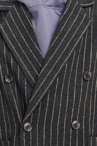 Blazer noir d'ORIGINALS BY JACK & JONES, avec un motif à carreaux et une fermeture à double bouton, porté sur un hoodie violet.