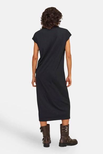 Robe noire à manches courtes de JJXX, vue de derrière et associée à des bottes brunes.