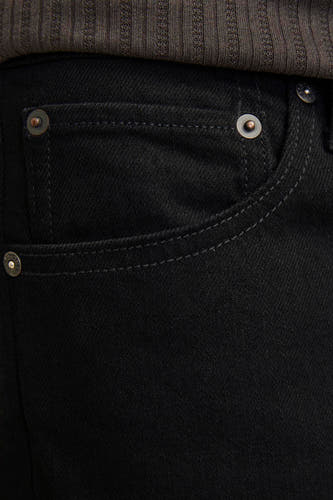 Zwarte tapered jeans van JACK & JONES JEANS INTELLIGENCE, met zakdetail en subtiele stiksels, gecombineerd met een ribgebreide top.
