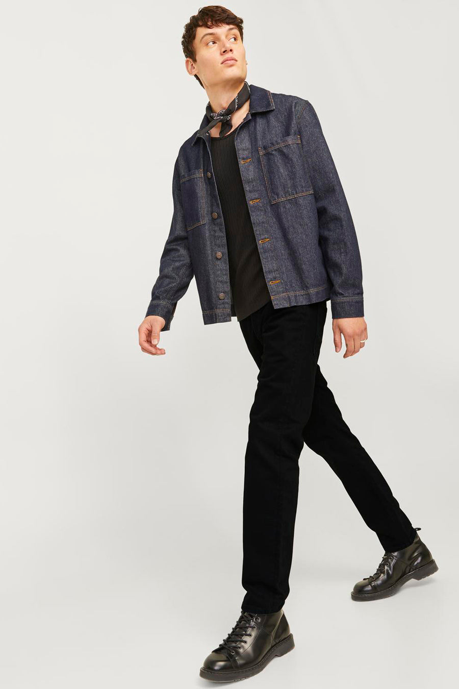 Jean tapered noir de JACK & JONES JEANS INTELLIGENCE, combiné avec une chemise en denim bleu foncé et des bottes en cuir noir.