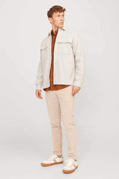 Chemise écru de PREMIUM par JACK & JONES, portée avec un t-shirt marron et un pantalon en corduroy.