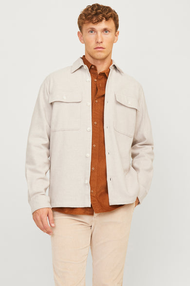 Chemise écru de PREMIUM par JACK & JONES, portée avec un gilet corduroy marron et des pantalons corduroy beige.