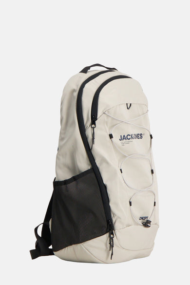 Sac à dos écru d'ACCESSORIES BY JACK & JONES, avec des accents noirs et des sangles élastiques à l'avant.