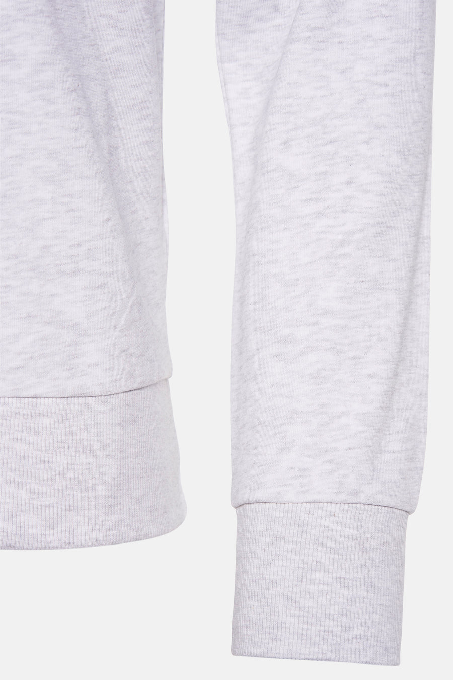 Twee mouwen van een grijze sweater met geribbelde manchetten.