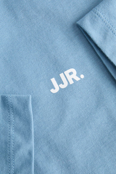 T-shirt bleu à manches courtes de JJREBEL, avec un gros plan des coutures et le logo sur la partie avant.