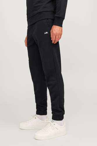 Short de JJ JJREJJBEL, avec le logo sur la sur et et des baskets blanches.