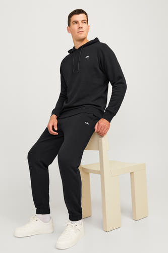 joggingou de noir JJ JJRERE porté par un homme des blancs et et et et, ass ass sur sur suris.