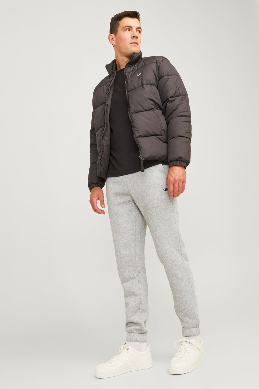 joggingamese JJ JJRERERERE, un un logo sur sur logo,éée avec une T-shirt noire et une veste polaire noire.