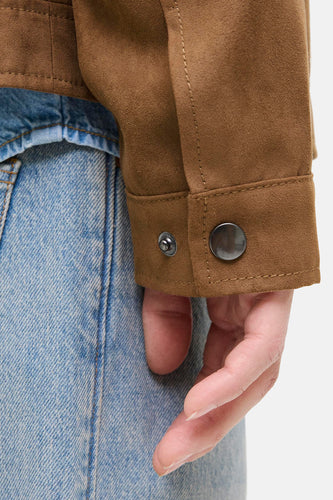 Bruin suède jack met spijkerbroek.